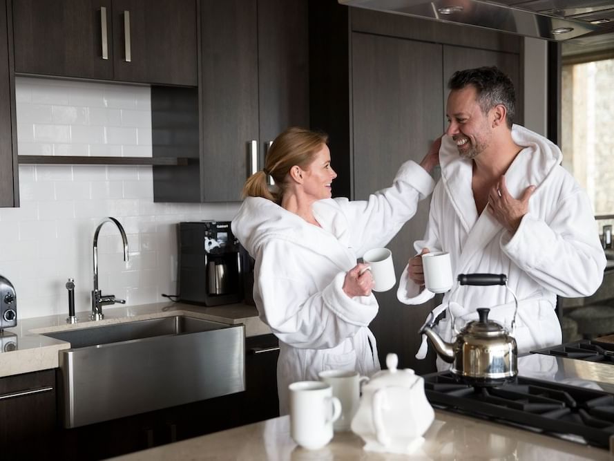 A couple in bathrobes about to enjoy tea in a guest room