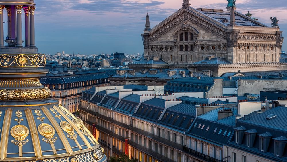 View of Paris rooftops and the Palais Garnier at twilightnear Warwick Hotels & Resort