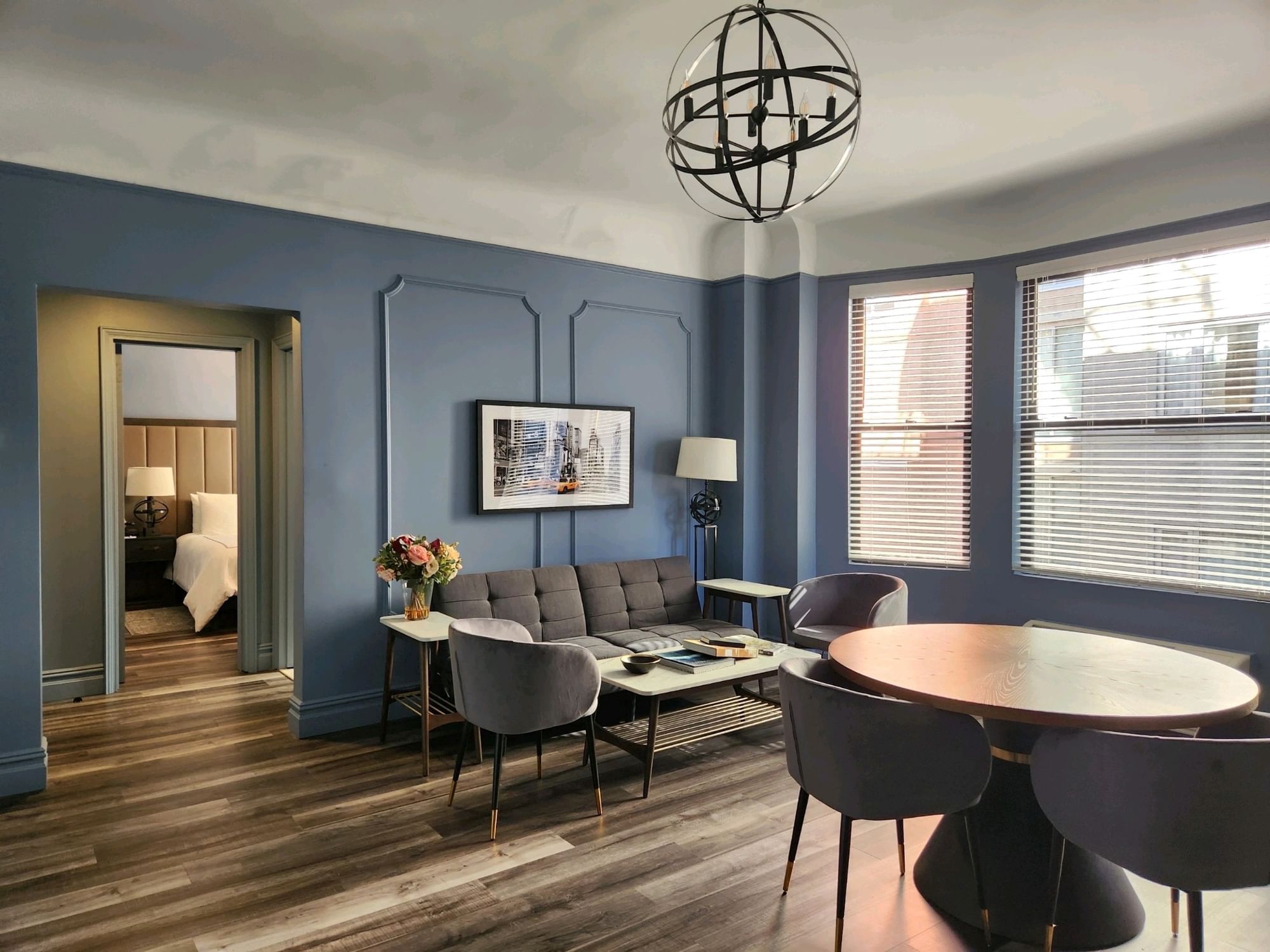 Dining table by lounge area in One-Bedroom Suite with wooden floors at Kixby Hotel