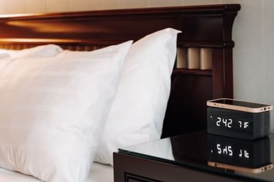 Nightstand with wireless phone charging clock in Junior King Suite at The St. Regis Hotel, a boutique hotel Vancouver