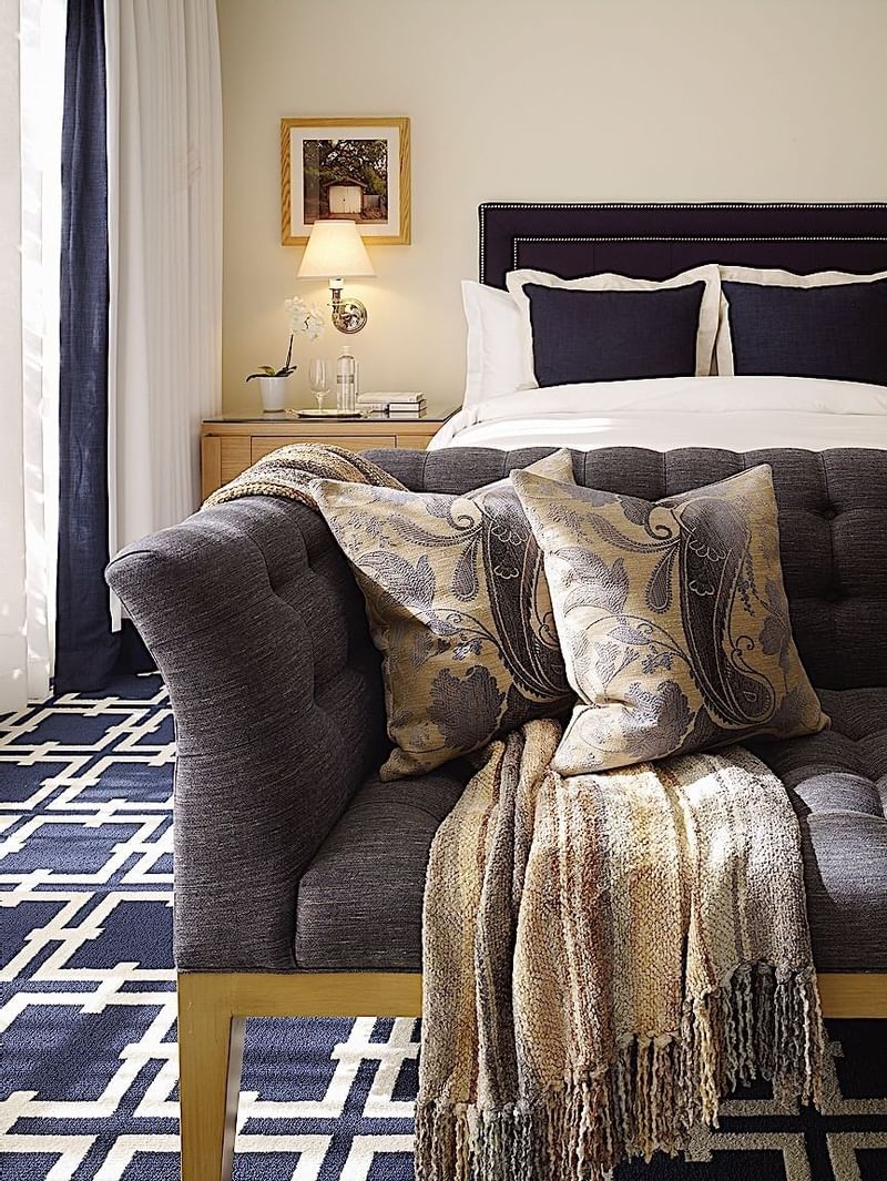 Room featuring a plush sofa with decorative pillows and a comfortable bed at El Prado Hotel