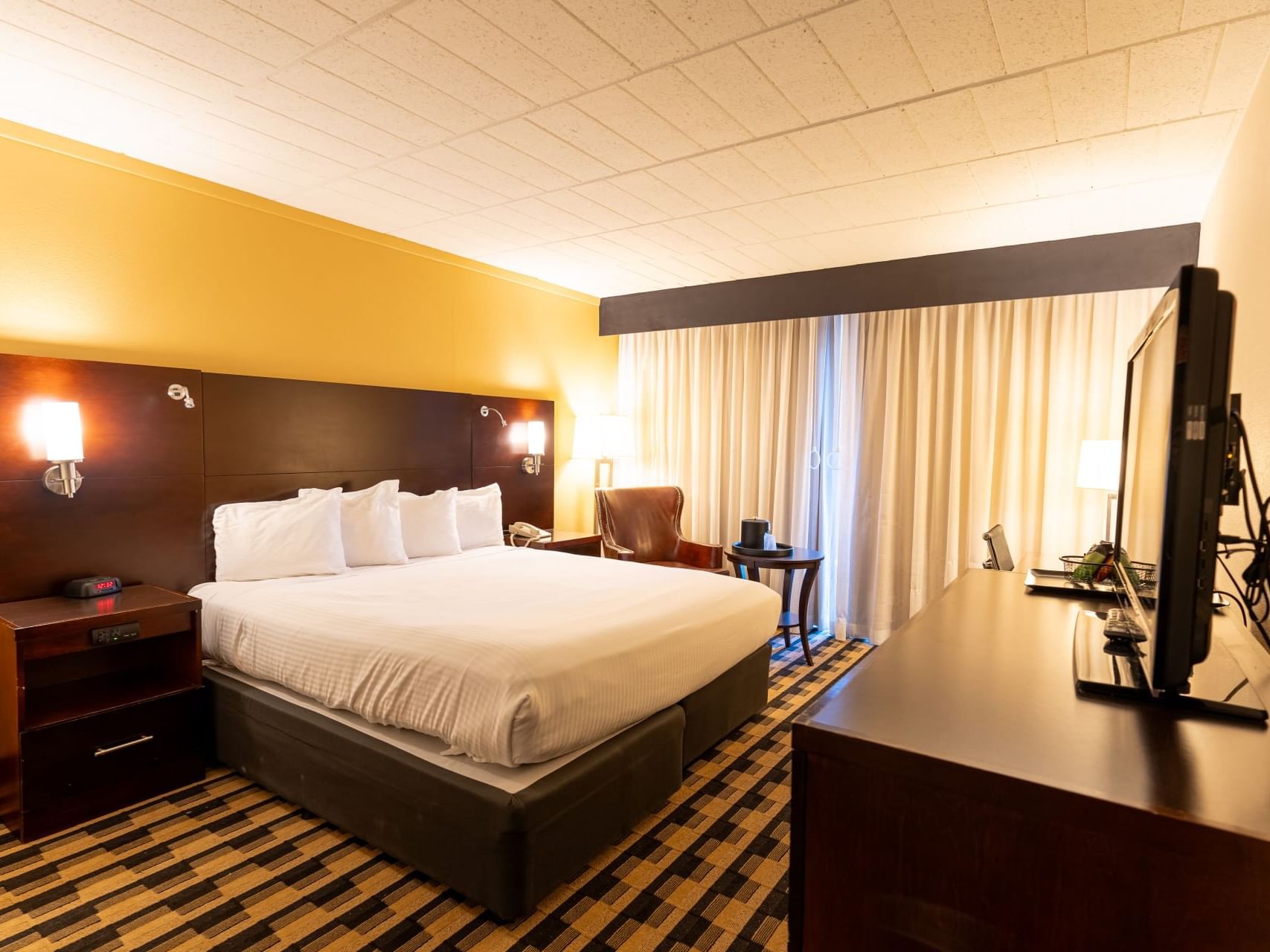 Classic King Room with a large bed, desk, and television at M Hotel Buffalo in Buffalo.