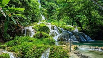 Mele Cascade Waterfalls cascading through a vibrant and green tropical jungle near the Warwick Le Lagon