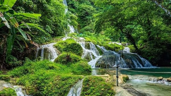 Mele Cascade Waterfalls cascading through a vibrant and green tropical jungle near the Warwick Le Lagon