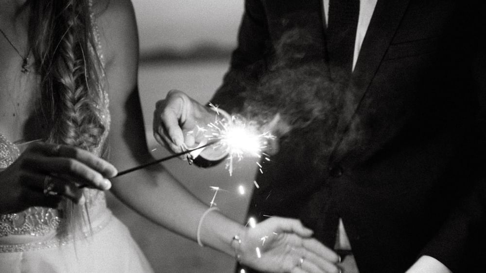 Couple lighting sparklers at Pullman Palm Cove Sea Resort