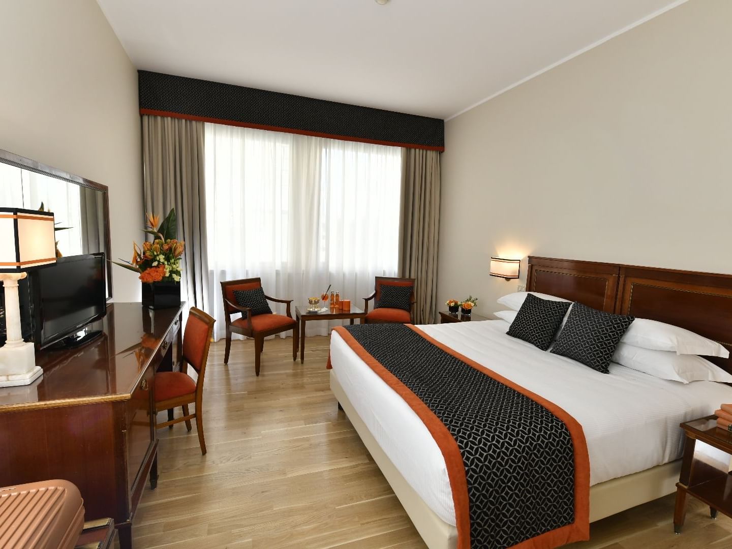 King bed, chairs with comfy pillows & Work desk with TV & Fresh Flowers in Deco Classic Room at Bettoja Hotel Mediterraneo