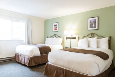 Room with two beds and nightstand at Alpenhof Lodge