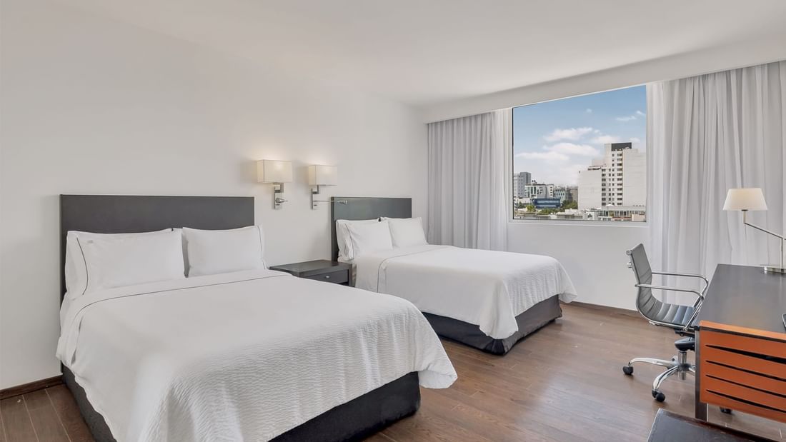 Work desk facing beds with city view in Superior Room, 2 Double at Fiesta Inn Insurgentes Sur