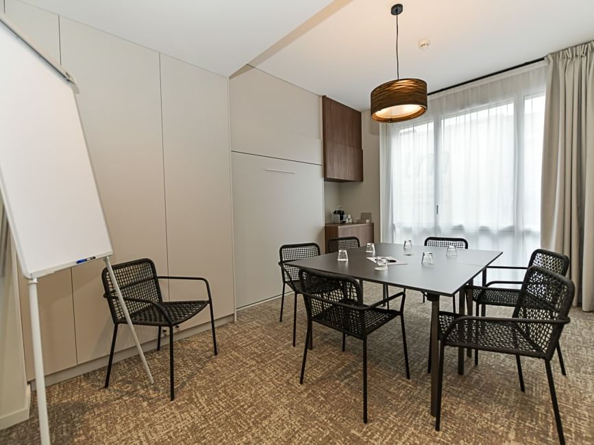Salle de réunion moderne avec table et chaises au Hôtel Rivella.