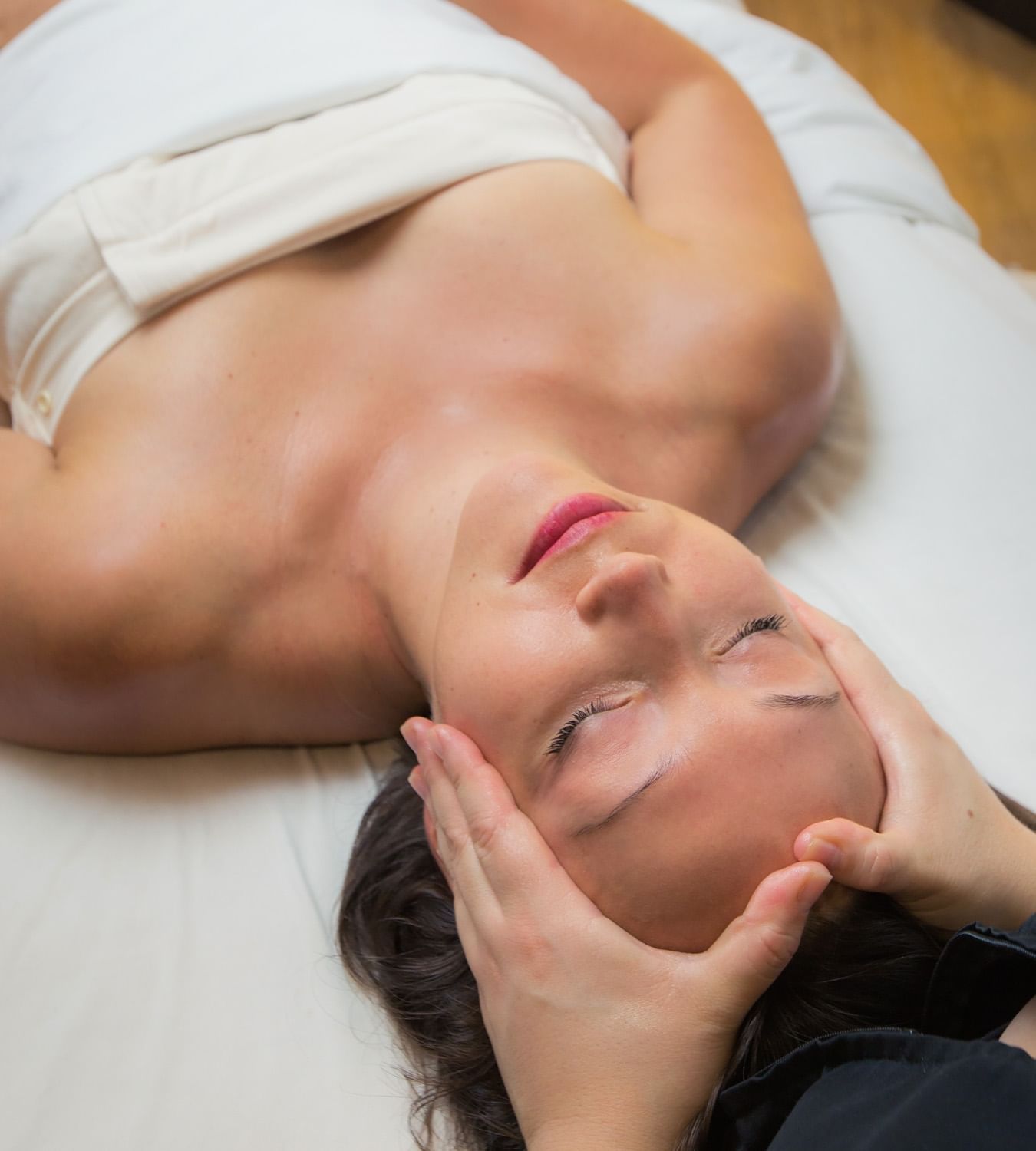 Woman laying face up getting a facial.