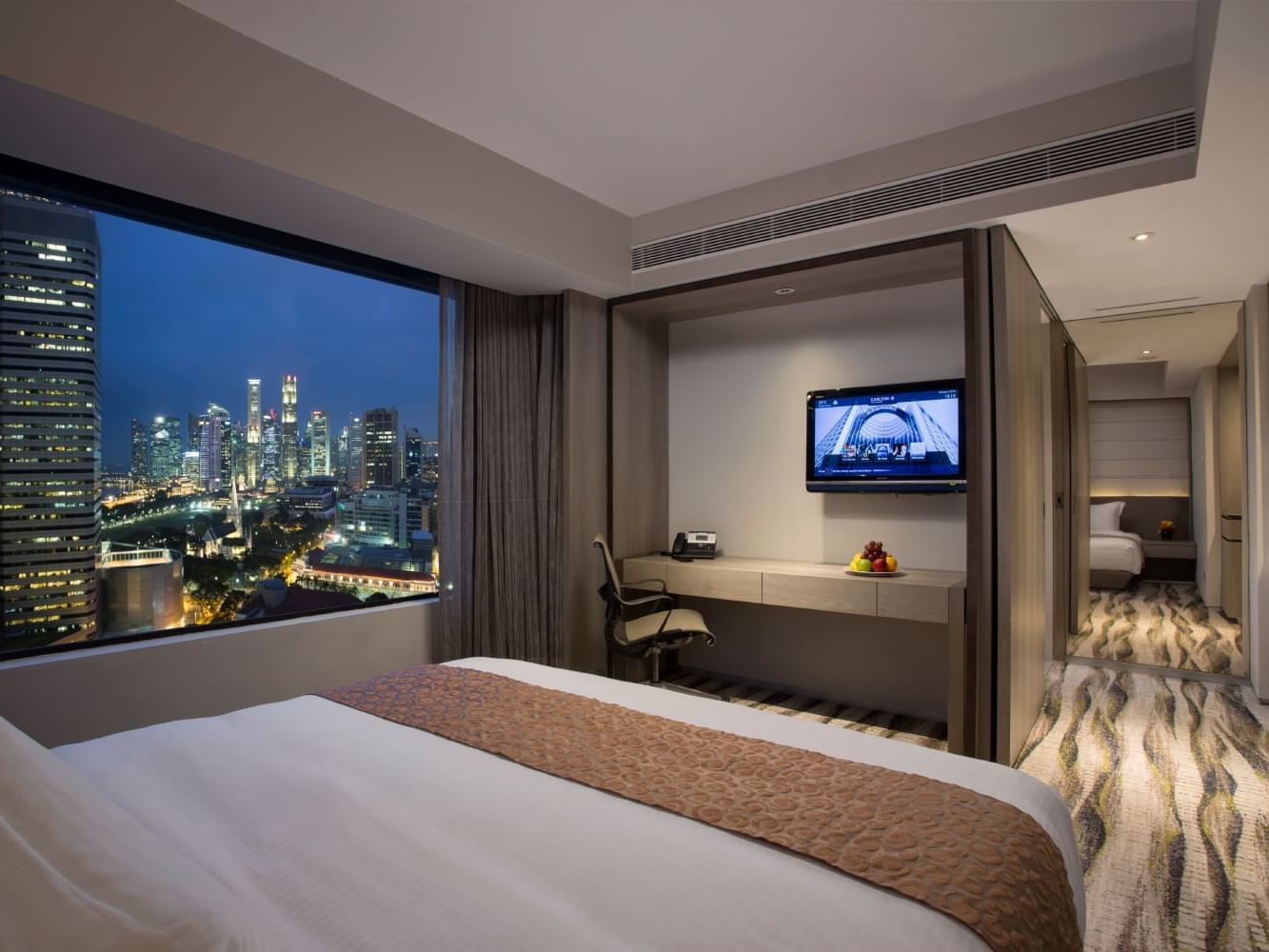 Bed & TV lounge area in Studio Room at Carlton Hotel Singapore