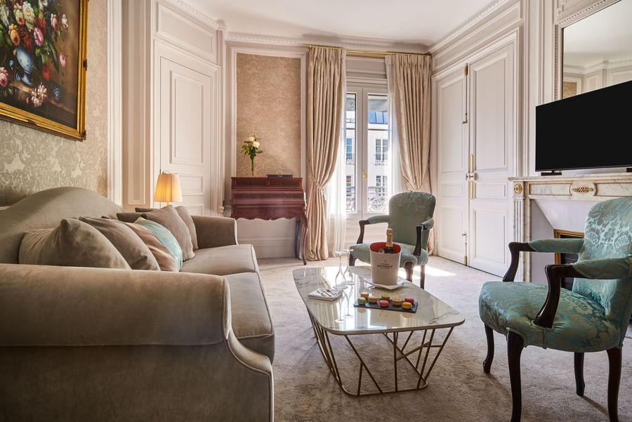 TV lounge with plush sofa near the curtain window in Prestige Suite – Rue de la Paix View at Hotel Westminster Paris