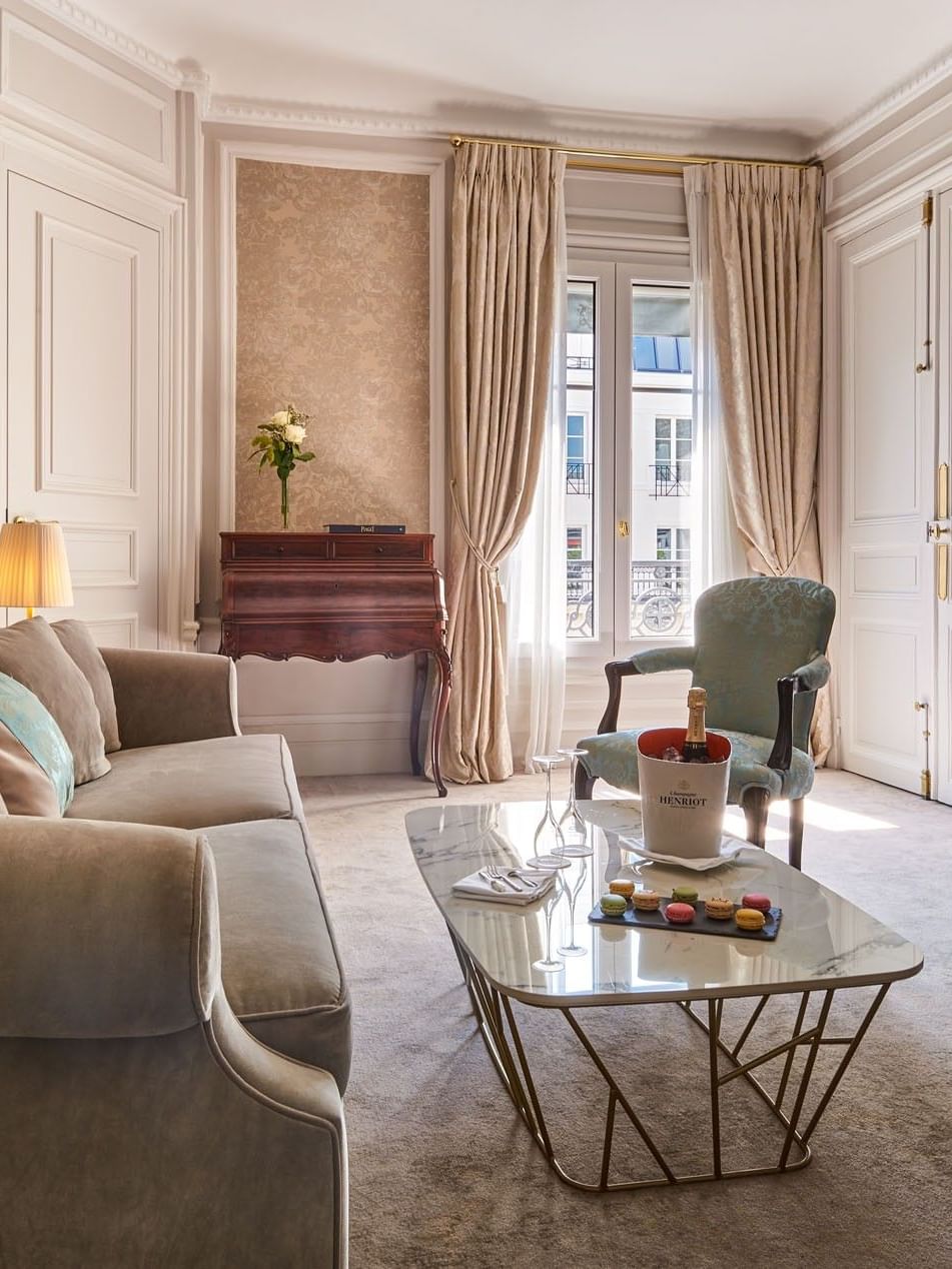 TV lounge with plush sofa near the curtain window in Prestige Suite – Rue de la Paix View at Hotel Westminster Paris