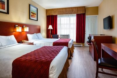 two large beds in hotel room with window