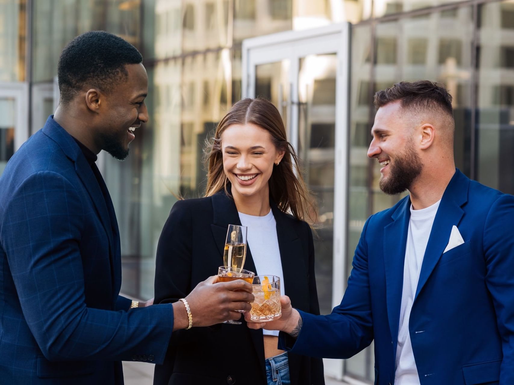 Three young corporate people enjoying drinks on a terrace
