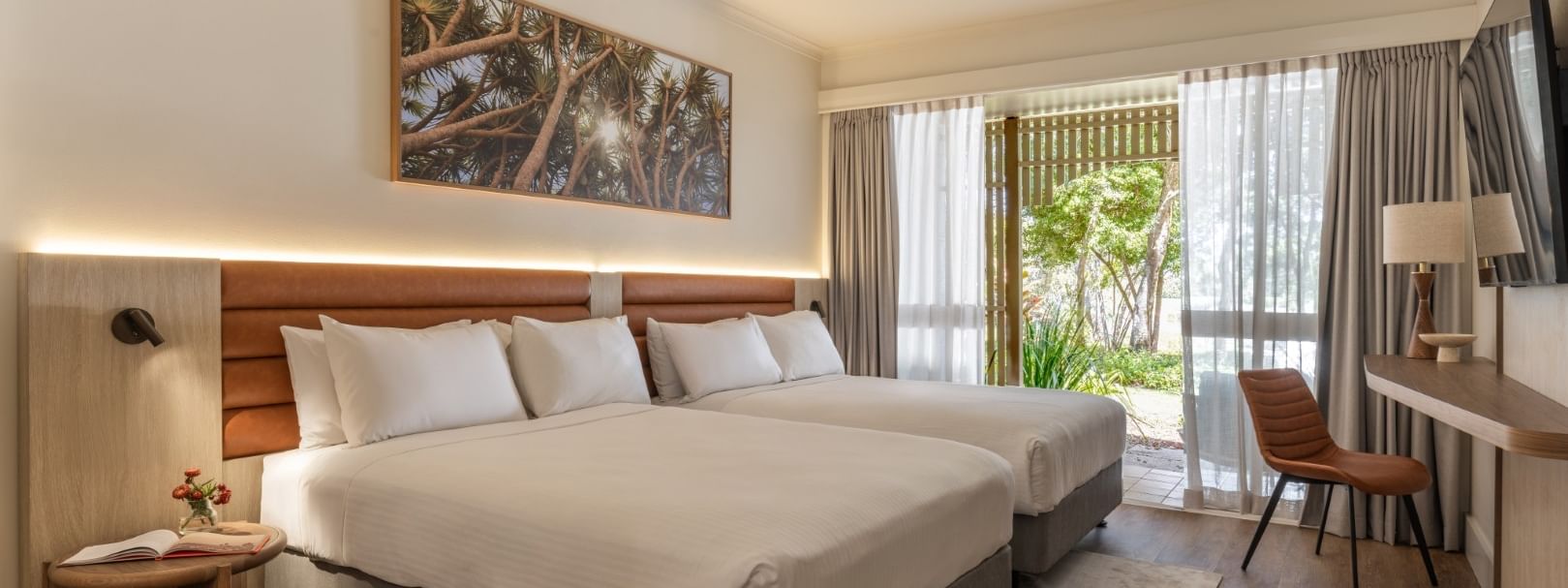 Deluxe room with two beds, wooden headboard, desk area, and balcony access at Novotel Sunshine Coast Twin Waters.