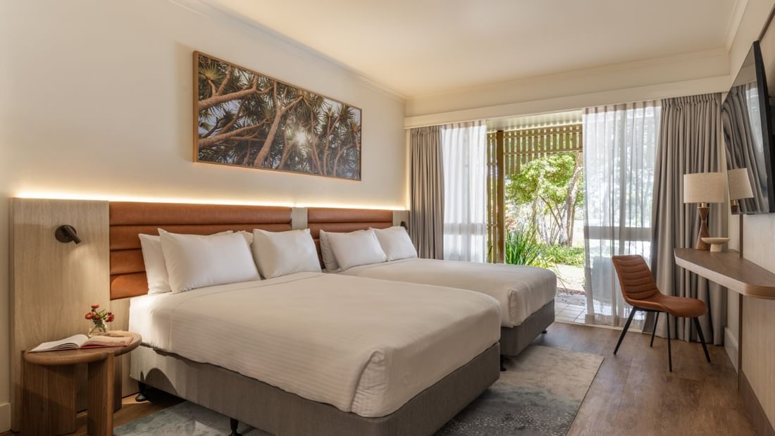Deluxe room with two beds, wooden headboard, desk area, and balcony access at Novotel Sunshine Coast Twin Waters.