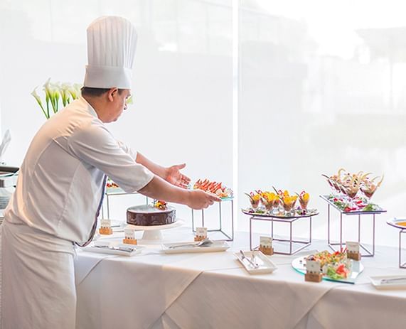 Chef setting the buffet at Oceanus Restaurant in Delfines Hotel