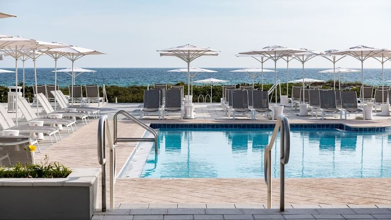 Lounges by the outdoor pool with handrails at WaterColor Inn