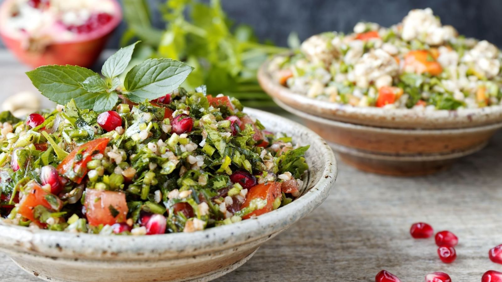 Fresh salad with mint leaves surrounding pomegranate seeds in a bowl at Warwick Ankara