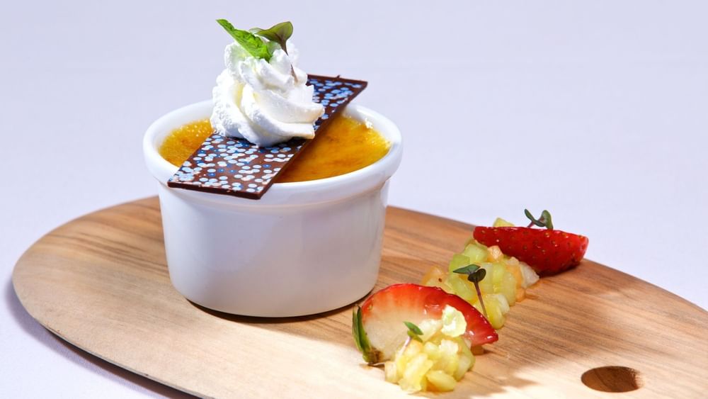 Custard dessert with fruit garnish under whipped cream in Edgewater Grill at Warwick Paradise Island Bahamas