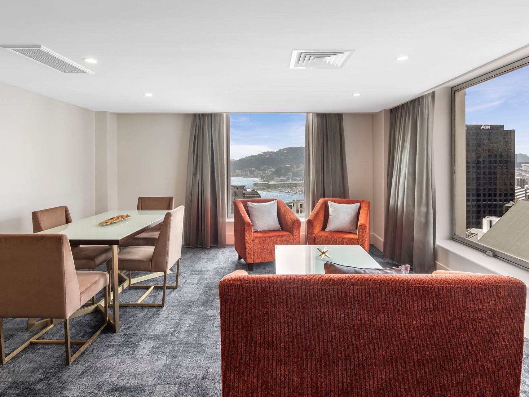 Deluxe Junior Suite lounge and dining area with city view at James Cook Hotel Grand Chancellor