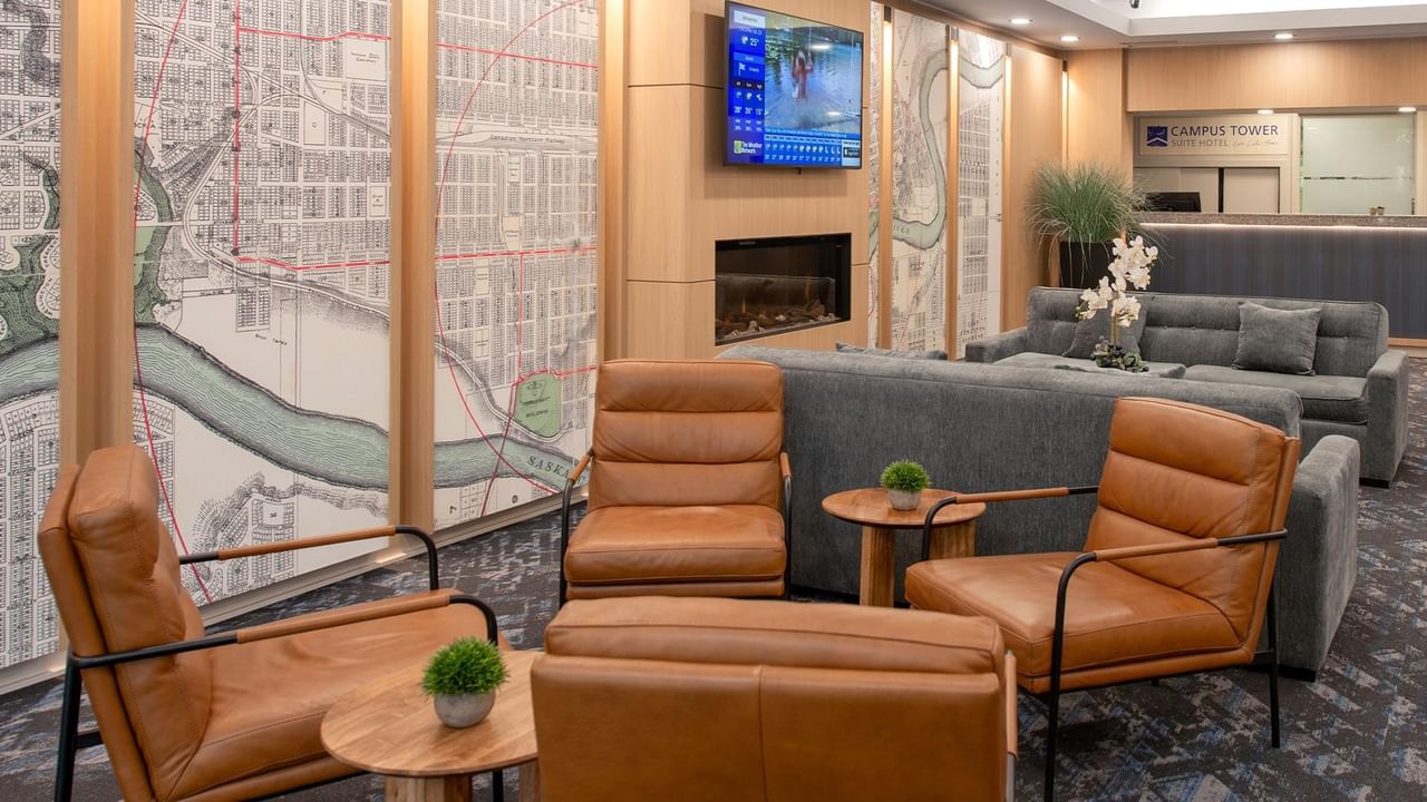 Hotel lobby seating area with leather armchairs, a sofa and wall artwork.