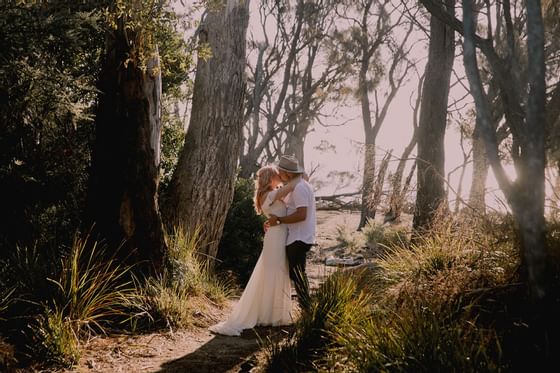 Portrait of a couple kissing in the woods at Freycinet Lodge