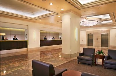 Reception desk by the lobby lounge area with a large chandelier in York Hotel Singapore