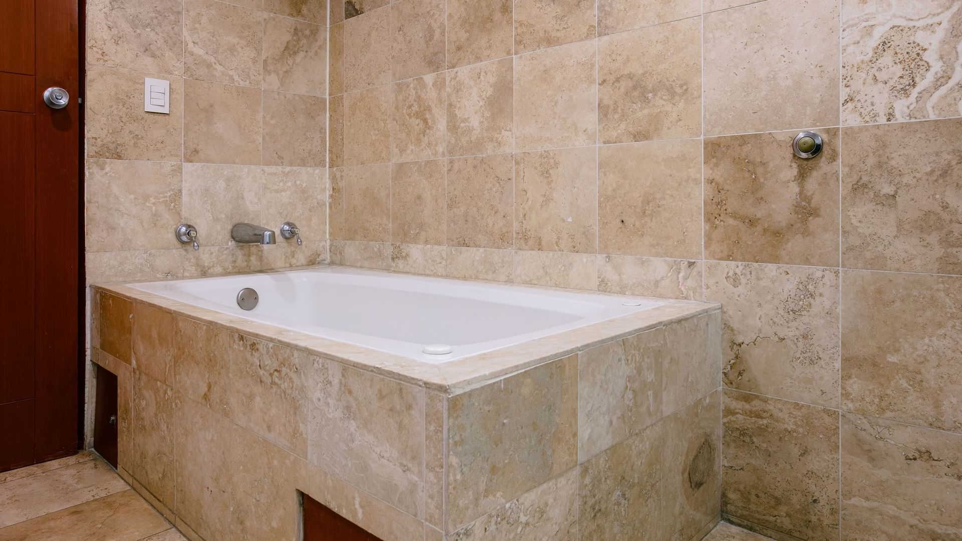 Tiled bathroom with a white bathtub and shower at Camino Real Guadalajara, Zapopan