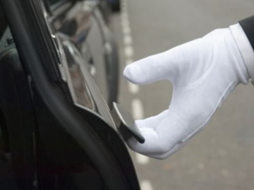 Closeup on a chauffeur opening a car door at Eastin Vientiane