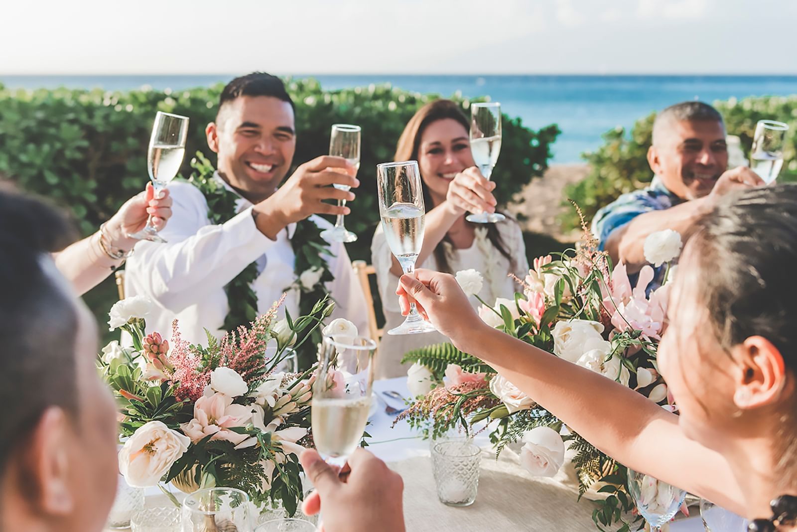 wedding party raising their glasses on beach