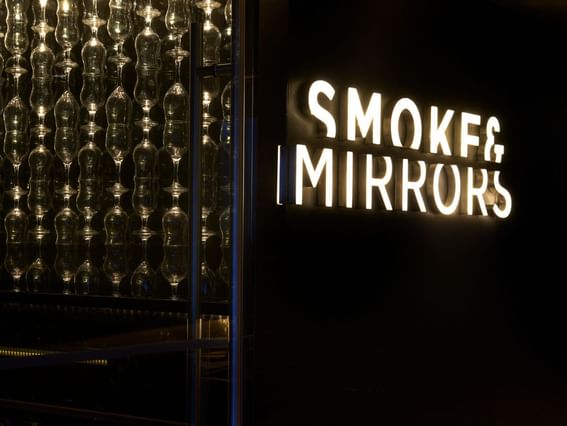 Close-up Smoke & Mirrors luminated signboard at Park Hotel Group