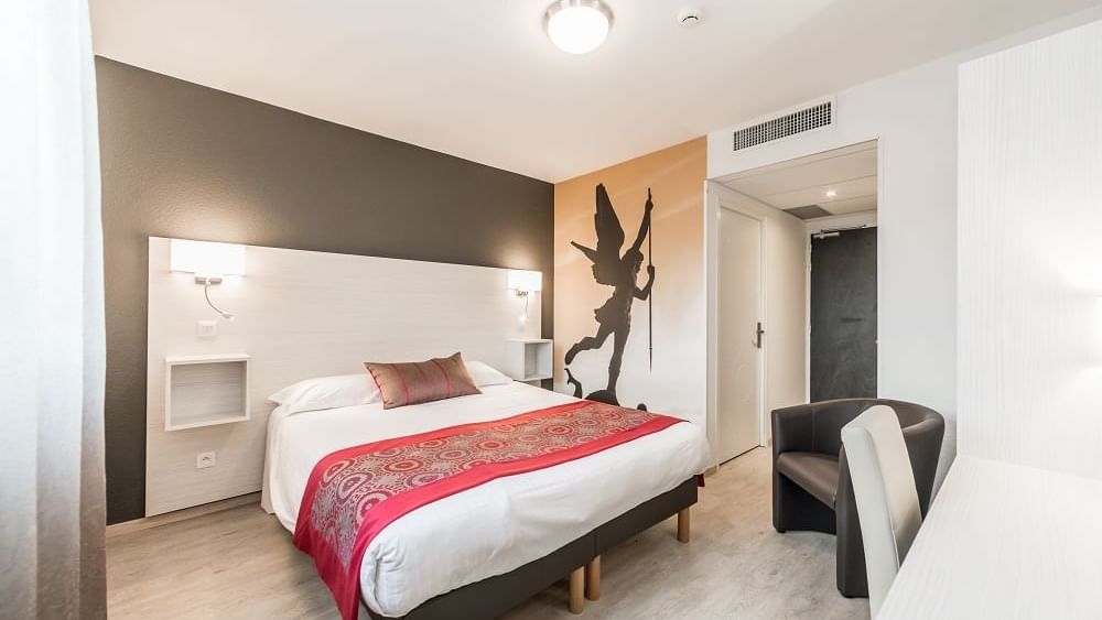 Double bed in bedroom at Hotel Les Quatre Salines
