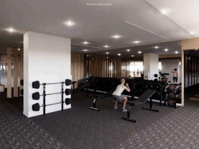 Modern gym with yoga room at UniLodge Brisbane City, showcasing equipment and a person exercising.