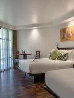 Two beds with garden view in a room at Warwick Fiji in Korolevu.