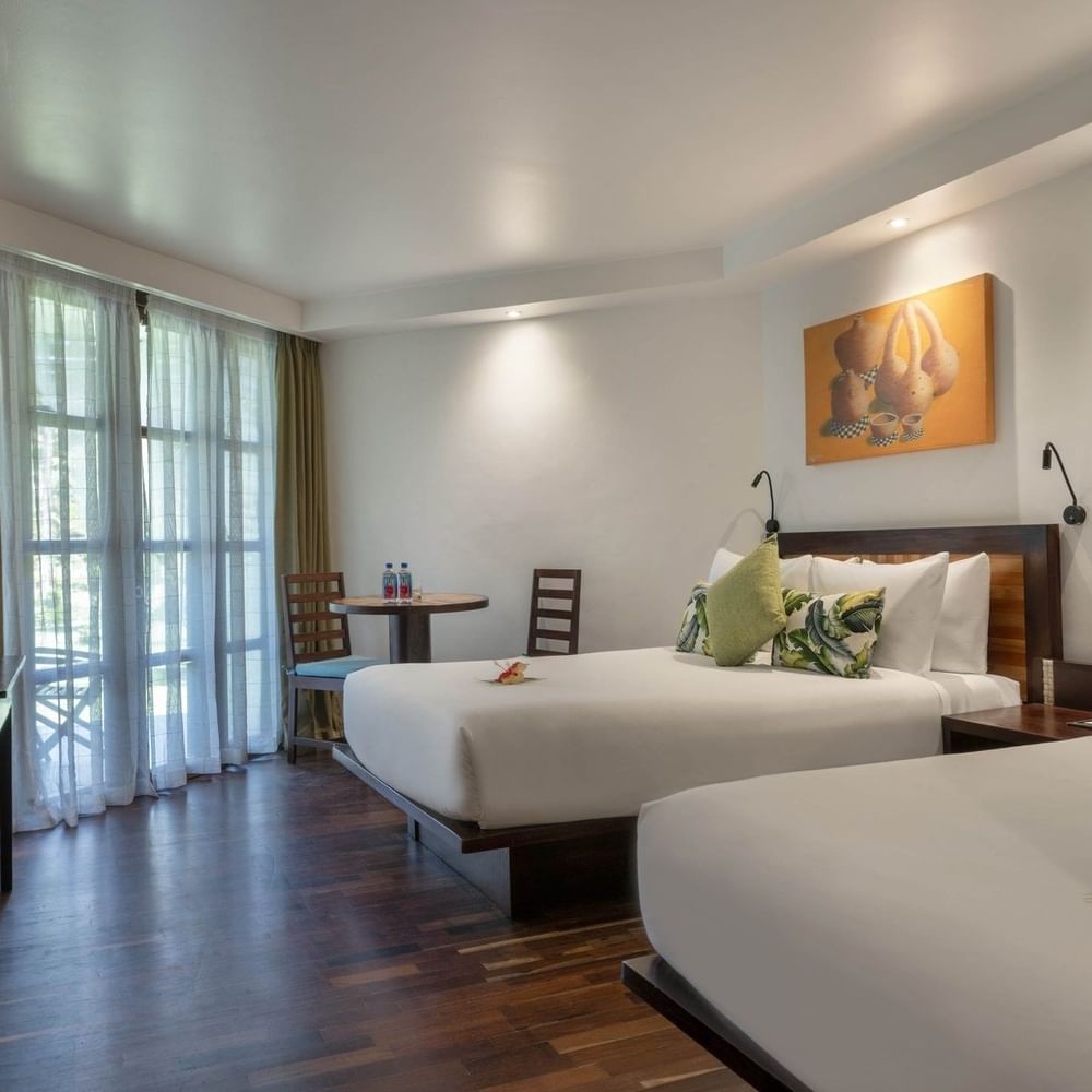 Two beds with garden view in a room at Warwick Fiji in Korolevu.