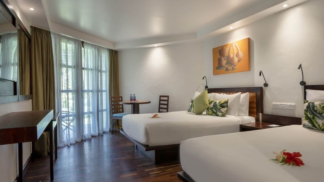 Two beds with garden view in a room at Warwick Fiji in Korolevu.