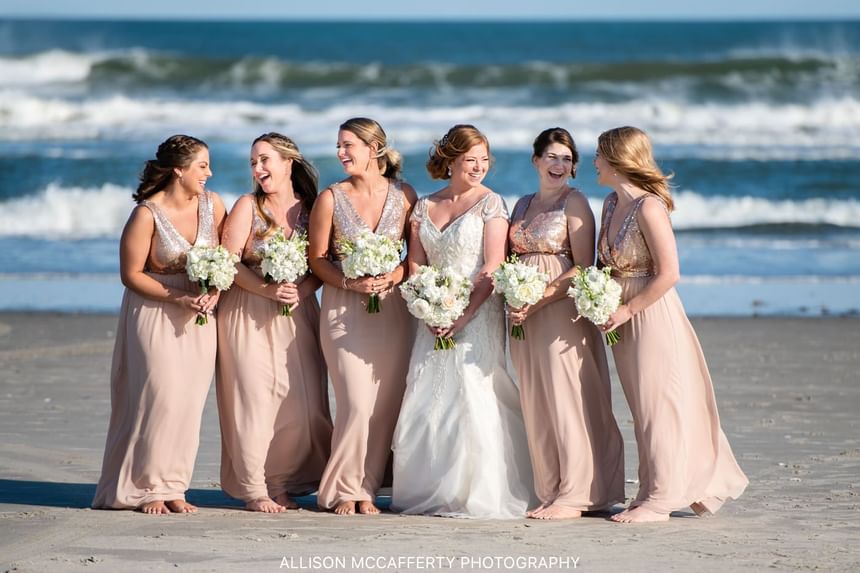 Bride with bridesmaids by the beach at ICONA Avalon Resort