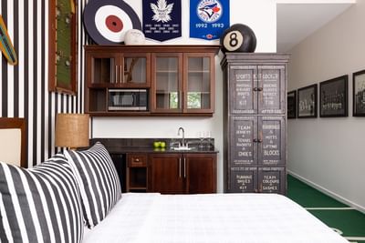 Queen bed, striped side cupboard & pantry in Queen Premiere at Retro Suites Hotel