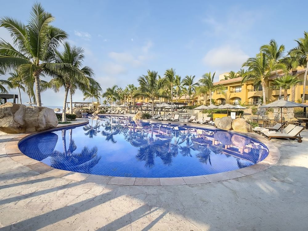 Outdoor pool with sun beds at Grand Fiesta Americana