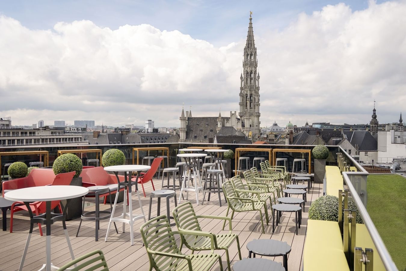 Dakterras met kleurrijke stoelen en tafels met uitzicht op de Brusselse skyline bij Warwick Brussels Bruxelles