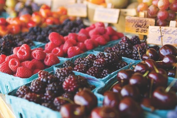 Raspberries, blackberries and other fruit in baskets at a farmers market