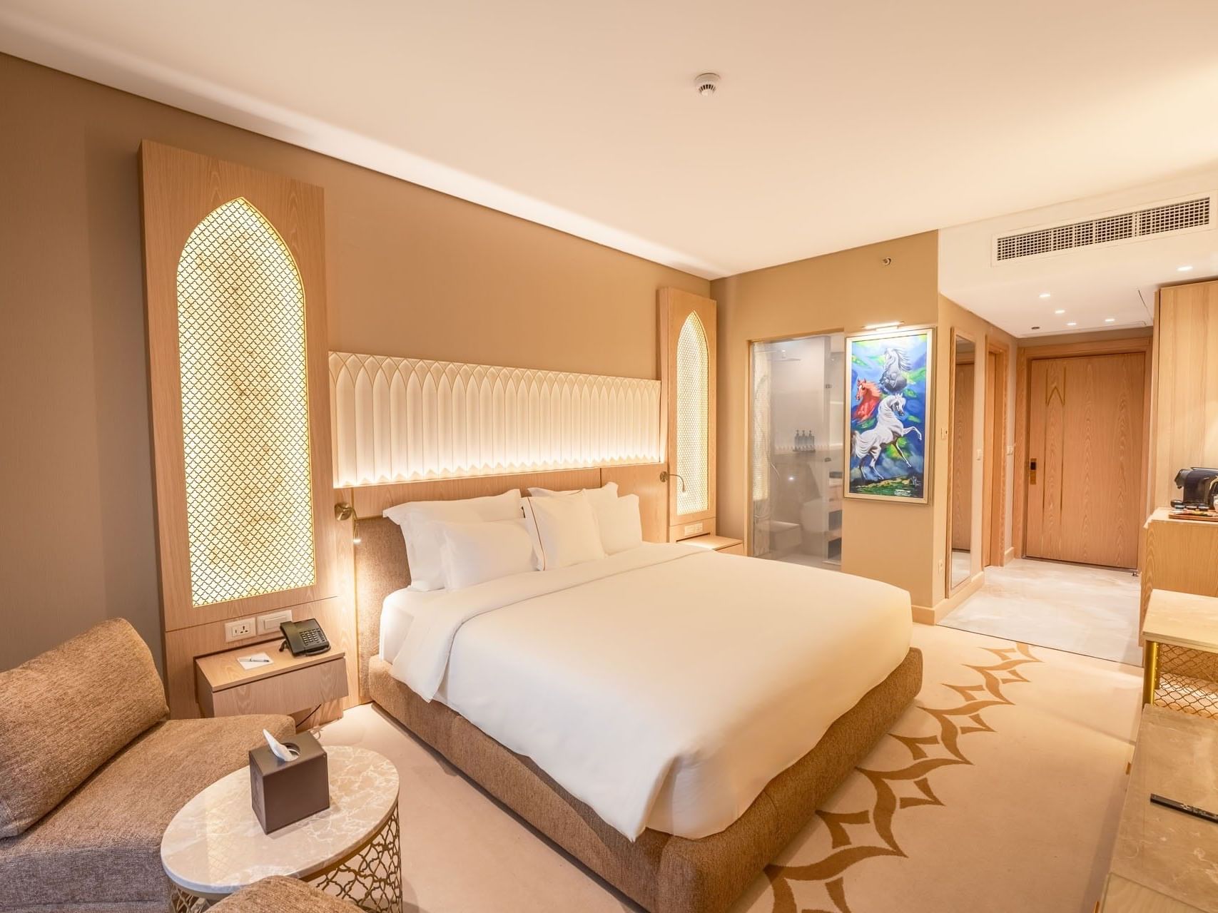 Elegantly designed hotel room with a large bed, seating area, and modern decor at World Heart Hotel Baghdad.