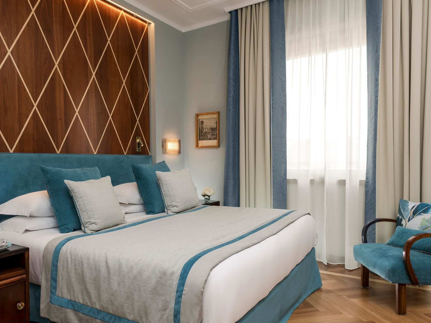 Comfy bed, blue pillows & chair in Premium Room at Bettoja Hotel Mediterraneo