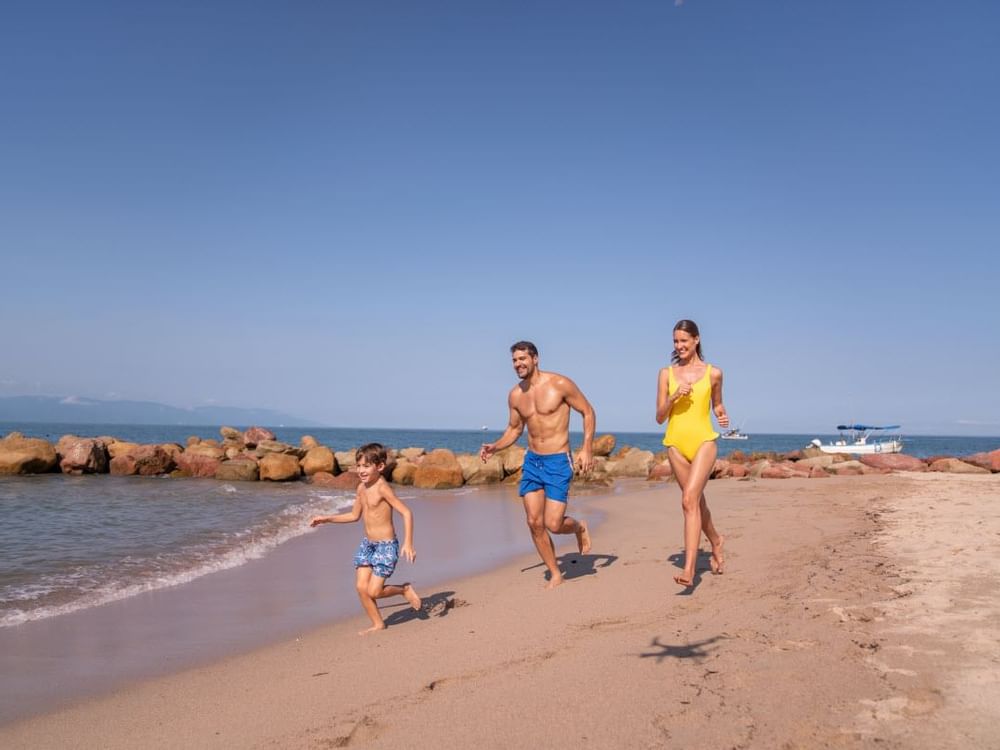 A family having fun at a beach near Gamma Hotels