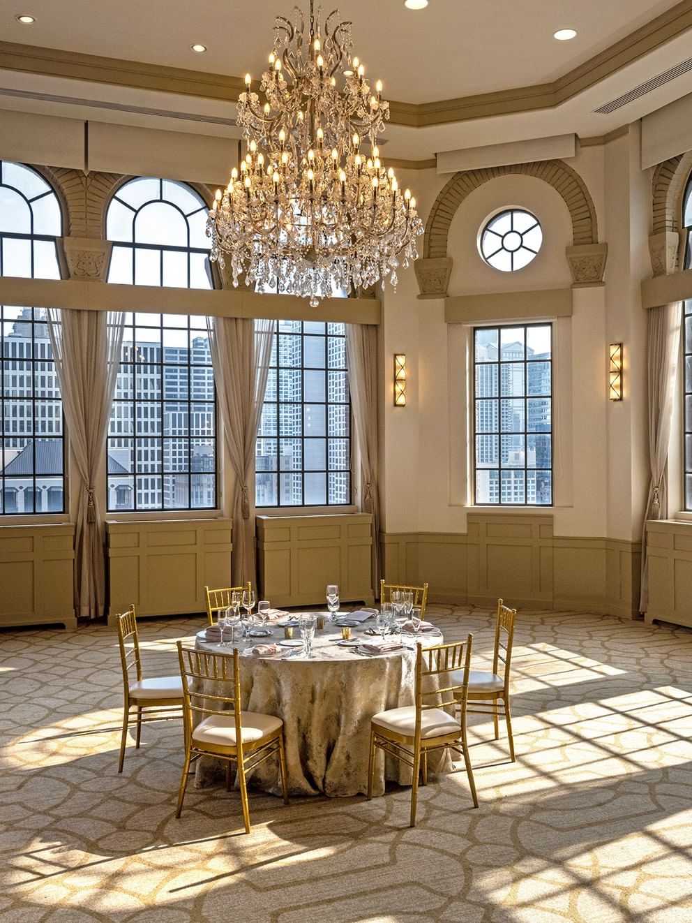Elegant Huron Room event space with large windows and a grand chandelier at Warwick Allerton - Chicago.