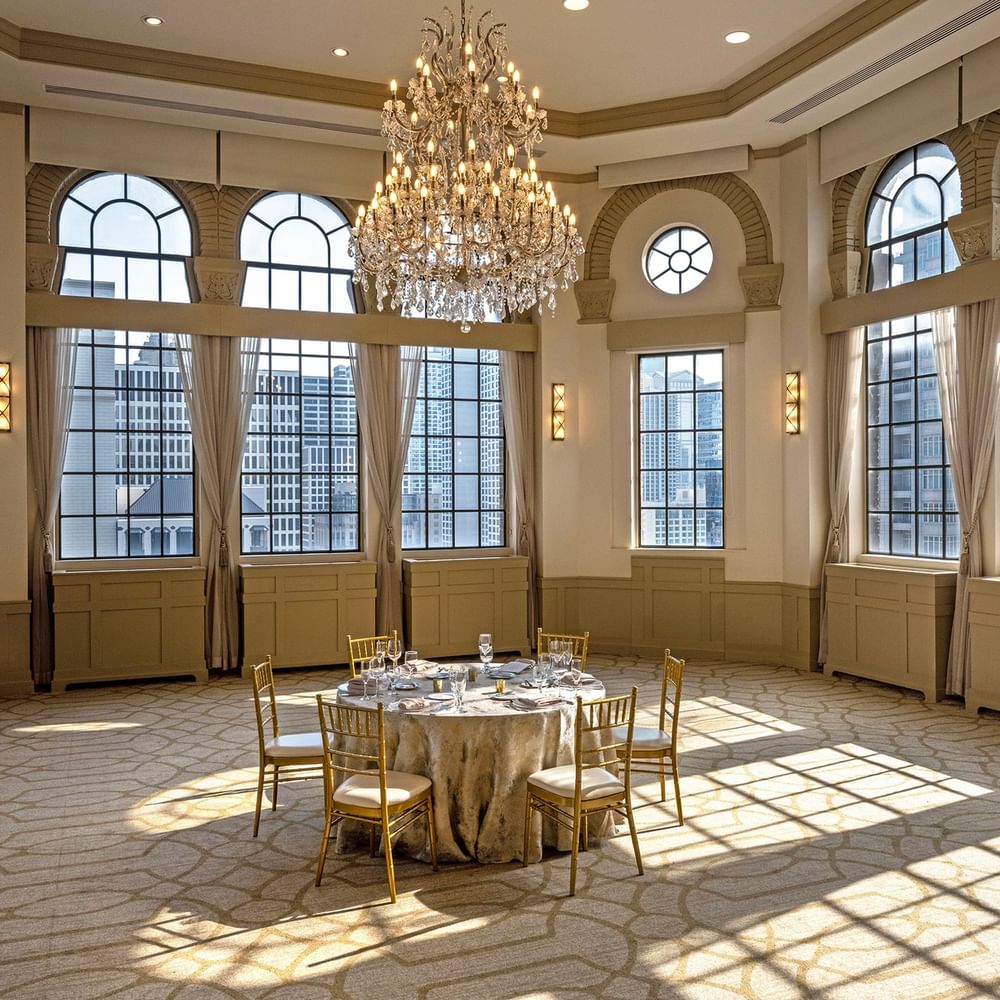 Huron Room with a setup banquet table near large windows under a grand chandelier at Warwick Allerton Chicago