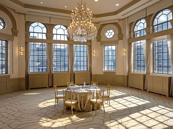 Huron Room with a setup banquet table near large windows under a grand chandelier at Warwick Allerton Chicago