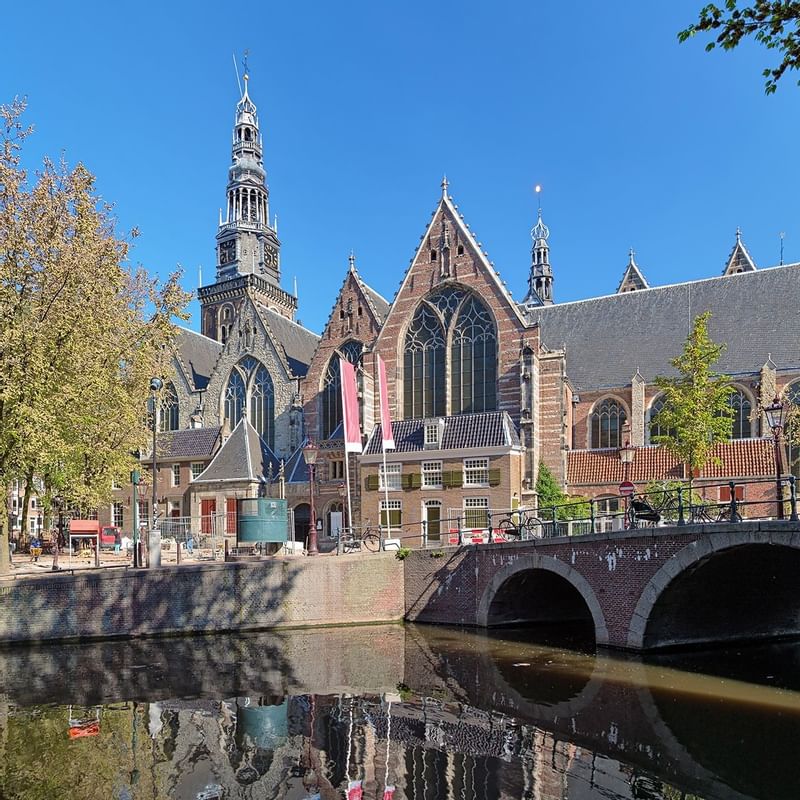 Distance view of Oude Kerk Amsterdam Art museum with bridge near Luxury Suites Amsterdam